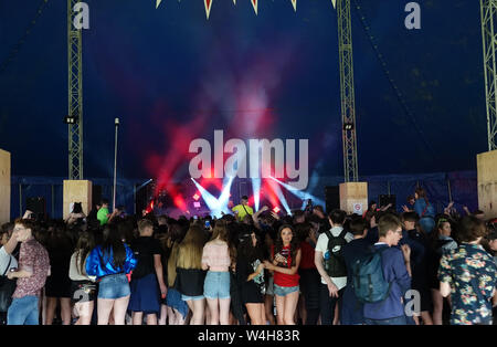Gli adolescenti ascoltando musica rave in una grande marca in un outdoor festival di musica Foto Stock