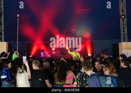 Gli adolescenti ascoltando musica rave in una grande marca in un outdoor festival di musica Foto Stock