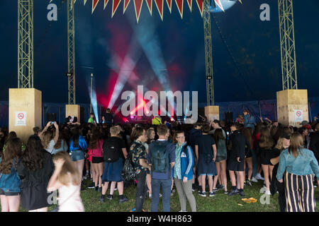 Gli adolescenti ascoltando musica rave in una grande marca in un outdoor festival di musica Foto Stock