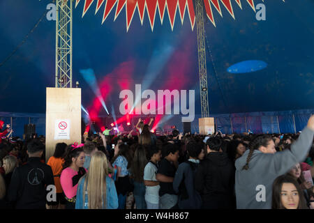 Gli adolescenti ascoltando musica rave in una grande marca in un outdoor festival di musica Foto Stock