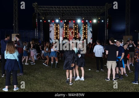 Gli adolescenti ascoltando musica rave in una grande marca in un outdoor festival di musica Foto Stock