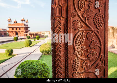 Un cortile al Fatehpur Sikri complesso con dettaglio di pietra scolpita pilastro in primo piano. Foto Stock