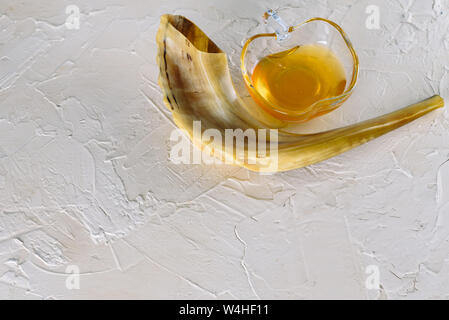 Rosh ha-shana Jewish nuovo anno composizione di una mela rossa, un vasetto di miele e Shofar avvisatore acustico per Rosh Hashanah. Foto Stock