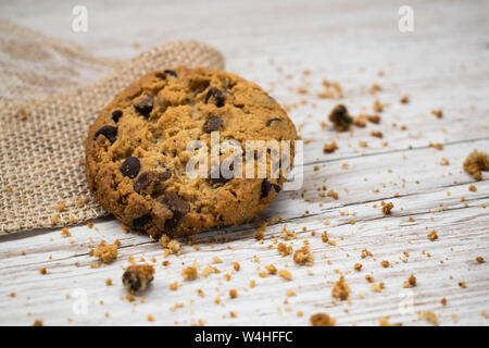 Pezzetti di cioccolato e tela tela su una tavola di legno Foto Stock