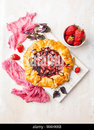 In casa di Fragola torta aperto gallet con basilico viola e condimento balsamico su uno sfondo luminoso. Vista superiore Foto Stock