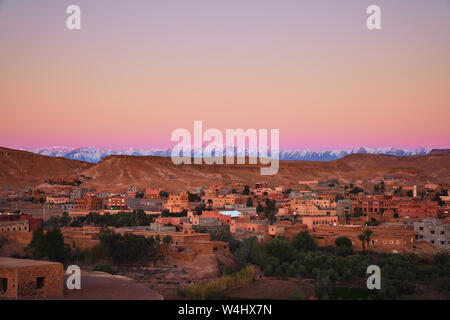 Bellissima alba sopra la coperta di neve montagne Atlas e una città nei pressi di Ait Ben Haddou fort in Marocco, Africa Foto Stock