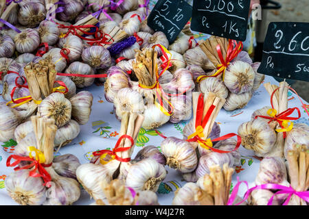 Un mercato in stallo Lavardac, in Francia, in Europa la vendita di bellissimi mazzetti di aglio fresco lampadine legati insieme con nastri Foto Stock