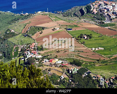 La vista dal Mirador de El lancia giù a Los Realejos e il marrone coltivato terrazza campi per la costa e la spiaggia di Playa del castro a Tenerife su th Foto Stock