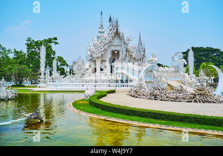 Esplorate uno dei più strani e ben noti templi buddisti della Thailandia - Wat Rong Khun o Tempio bianco, famosa per le sue uniche sculture in stucco, Foto Stock