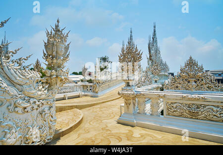 Stucco decorativo dettagli del bianco (tempio Wat Rong Khun) includono gli intricati intarsi, specchio, modelli di sculture di multi-guidato metà umane semi-serp Foto Stock