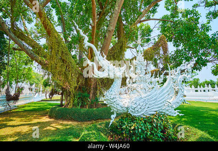 La bianca statua dello stucco del mitico half-elephant semi-bird creatura di hatsadiling (NOK hatsadi, nok hat, hatsading) in ombra di diffusione di albero in Wh