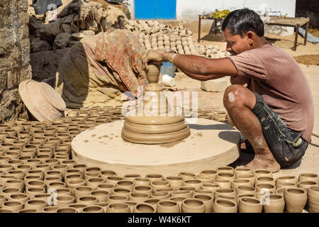 Bikaner, India - 12 Febbraio 2019: Indiano potter rendendo pentole di creta sulla ruota di ceramiche in Bikaner. Rajasthan Foto Stock