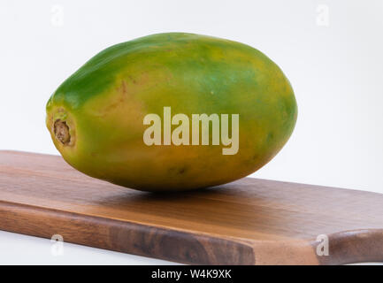 La papaia matura isolata su una tavola di legno. Sfondo bianco Foto Stock
