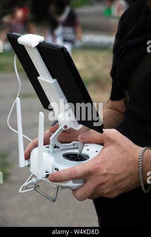 L'uomo operatore è in possesso di un pannello di controllo per il fuco. L'uomo controlla il drone con un tablet. Foto Stock