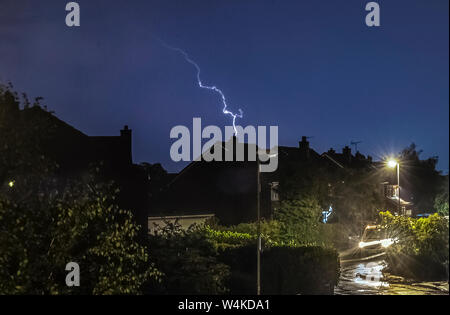 Un fulmine colpisce come un temporale passa sopra le case di Leeds, West Yorkshire. Il Regno Unito è previsto a bordo verso il suo sempre più calda giornata di luglio con il mercurio a causa di elevarsi al di sopra di 30C (86F). Foto Stock