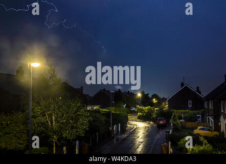 Un fulmine colpisce come un temporale passa sopra le case di Leeds, West Yorkshire. Il Regno Unito è previsto a bordo verso il suo sempre più calda giornata di luglio con il mercurio a causa di elevarsi al di sopra di 30C (86F). Foto Stock