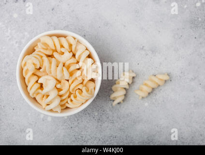 Sale e aceto potato ghirigori in bianco ciotola, classico snack luce sul tavolo della cucina. Foto Stock