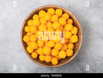 Golden soffiato palline di formaggio come classico snack per bambini sul tavolo luminoso. Vista superiore Foto Stock