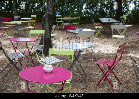 Cafe colorati tavoli e sedie nel giardino ombreggiato Foto Stock