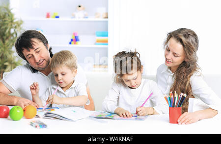 Ritratto di una gioiosa famiglia utilizzando un laptop seduto sul divano di casa Foto Stock