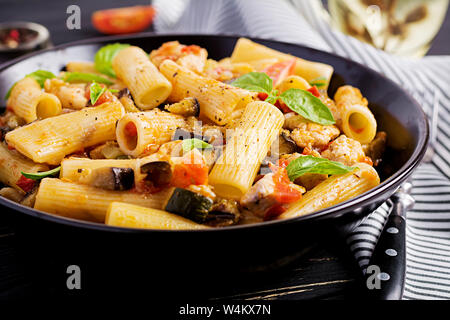 Rigatoni Pasta con carne di pollo, le melanzane in salsa di pomodoro nel recipiente. Cucina Italiana. Foto Stock