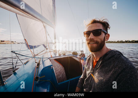 Uomo adulto su marina della barca sport ritratto felice rilassato su un tramonto Foto Stock