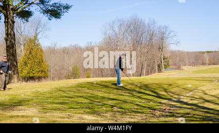 Un campo di rinvio su un campo da golf. Un paio di golfisti sono visto la preparazione al tee off dal primo foro di un campo da golf. Foto Stock