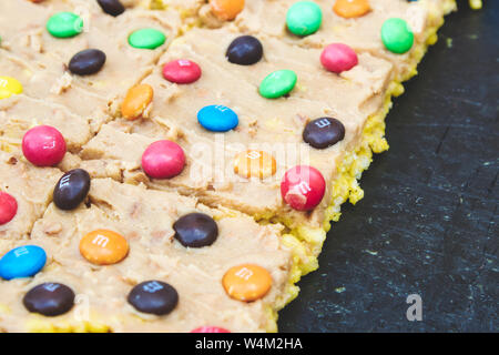 Multi-colore di M&Ms su una fetta di flapjack fatti in casa con glassa, 12 maggio 2019 Foto Stock