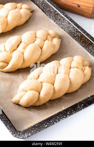 Cibo fatto in casa concetto processo risultava treccia di pane challah impasto su sfondo bianco con spazio di copia Foto Stock