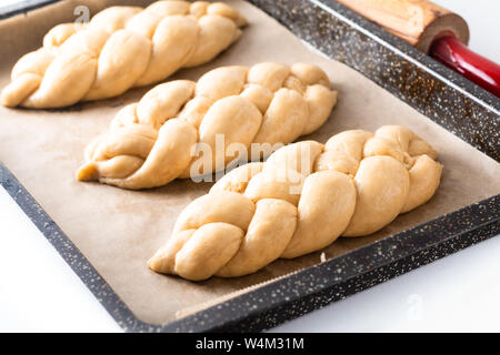 Cibo fatto in casa concetto processo risultava treccia di pane challah impasto su sfondo bianco con spazio di copia Foto Stock