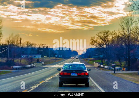 Le vetture che esercitano su una regione del Nord della superstrada del Michigan, USA, sotto un colorato del cielo della sera. Foto Stock