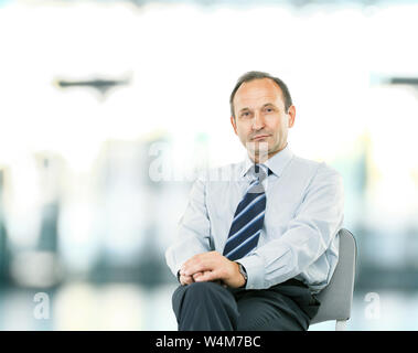 Portrait - avvocato consulente seduto nella mia poltrona scrivania sulla luce sfondo sfocato foto ha uno spazio vuoto per il testo Foto Stock