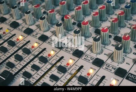 Close-up di mixaggio audio scrivania con manopole e cursori Foto Stock