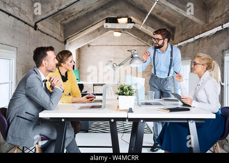 Gruppo di imprenditori creativi durante la riunione in ufficio moderno Foto Stock