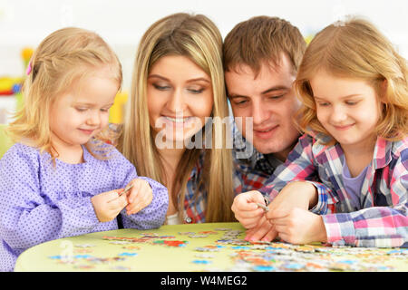 I genitori e i bambini raccolta di puzzle e posa a casa Foto Stock
