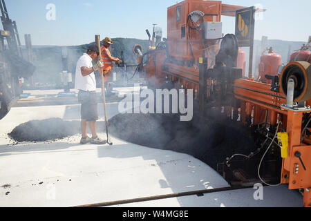 24 luglio 2019, Renania-Palatinato, Zeltingen-Rachtig: i lavoratori asfalto la superficie stradale del ponte Hochmosel in costruzione a temperature ben al di sopra di 30 gradi Celsius. Non vi è alcun luogo ombroso su 160 metri di un edificio alto sopra la valle di Mosel. Foto: Thomas Frey/dpa Foto Stock