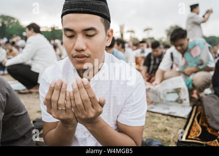 Uomo asiatico pregare preghiera Eid Foto Stock