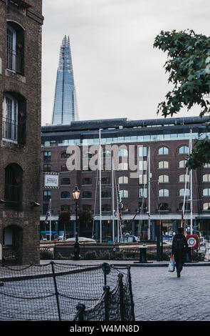 London, Regno Unito - 22 Giugno 2019: persona cammina in St Katharine Docks, un ex banchina convertito in marina e il quartiere commerciale e residenziale di Centra Foto Stock