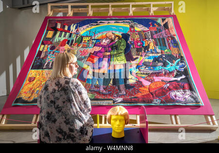 Gallery davanti casa manager Sinead Bracken prende uno sguardo ad alcuni dei lavori di tappezzeria per artista Grayson Perry prima che la mostra è aperta al pubblico presso la Colombaia Studios di Edimburgo. Foto Stock