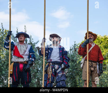 Tre gli attori locali in costume rinascimentale e portante le lance in attesa di prendere parte al festival dell'estate in una piccola città in Italia. Foto Stock