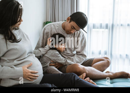 La tristezza della bambina con la madre e il padre abbraccio Foto Stock