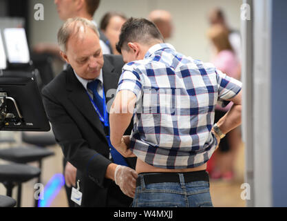 24 luglio 2019, Assia, Frankfurt/Main: a un passeggero che viaggi in aereo è controllato in un nuovo padiglione costruito nel Terminal 1 dell'aeroporto di Francoforte. Le sette nuove corsie di controllo sono destinati a garantire il funzionamento regolare. Grazie a una nuova configurazione, più passeggeri per ora può essere guidato attraverso il rispetto con la tecnologia utilizzata in precedenza. Foto: Arne Dedert/dpa Foto Stock