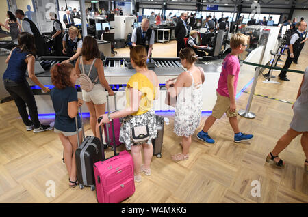 24 luglio 2019, Assia, Frankfurt/Main: i passeggeri del trasporto aereo sono in piedi a un passeggero checkpoint in un nuovo capannone costruito nel Terminal 1 dell'aeroporto di Francoforte. Le sette nuove corsie di controllo sono destinati a garantire il funzionamento regolare. Grazie a una nuova configurazione, più passeggeri per ora può essere guidato attraverso il rispetto con la tecnologia utilizzata in precedenza. Foto: Arne Dedert/dpa Foto Stock