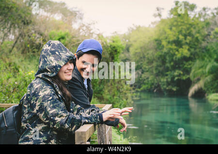 Giovane su un eco turismo durante l'inverno. Coppia felice godere la natura in un freddo giorno di pioggia. Bonito MS, Brasile. Foto Stock