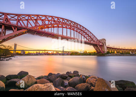 New York, New York, Stati Uniti d'America a Hell Gate Bridge al tramonto sull'East River. Foto Stock