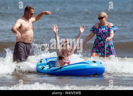 Stephen Johnston (posteriore sinistra) con Louisa Burniston (parte posteriore destra), Charlotte Burniston (in barca nuovamente), Justin McNicholas su Scarborough Beach come il Regno Unito è previsto a bordo verso il suo sempre più calda giornata di luglio con il mercurio a causa di elevarsi al di sopra di 30C (86F). Foto Stock