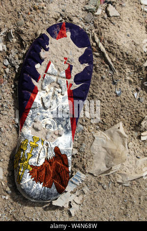 La bandiera di Samoa Americane è raffigurato sulla suola di un vecchio boot. Concetto di ecologia con inquinamento ambientale da rifiuti domestici e industriali. Foto Stock