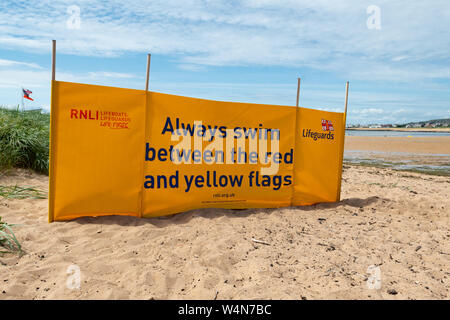 Sempre nuotare tra il giallo e il rosso bandiere banner a Elie beach, Fife, Scozia, Regno Unito Foto Stock