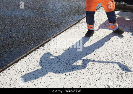 Rachtig Zeltingen, Germania. Il 24 luglio, 2019. I lavoratori di asfaltatura della superficie stradale del ponte Hochmosel in costruzione a temperature molto al di sopra di 30 gradi Celsius. Non vi è alcun luogo ombroso su 160 metri di un edificio alto sopra la valle di Mosel. Credito: Thomas Frey/dpa/Alamy Live News Foto Stock