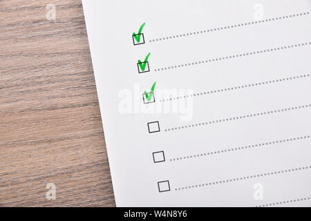 Questionario concetto con diverse opzioni con selezioni in colore verde su un tavolo di legno. Composizione orizzontale. Vista dall'alto. Foto Stock